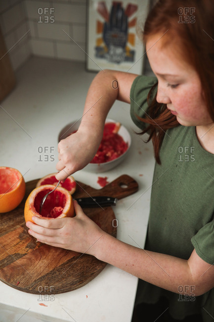 Girl preparing a grapefruit snack
