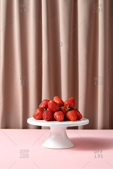Delicious ripe strawberries on a white porcelain cake stand