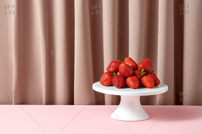 Delicious ripe strawberries on a white porcelain cake stand
