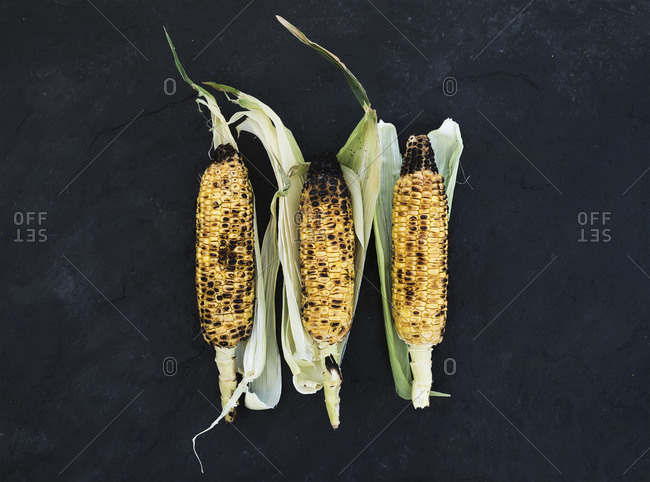 Grilled corn over black slate stone background