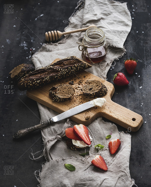 Black baguette toasts with fresh strawberries, honey and mascarpone cheese