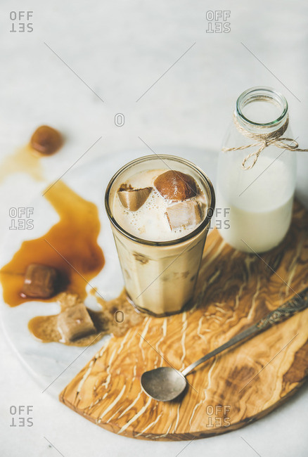 Iced caramel latte summer coffee cocktail with milk and frozen coffee ice cubes
