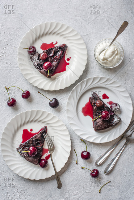 Chocolate, amaretto and cherry brownie with cream and fresh cherries, sliced