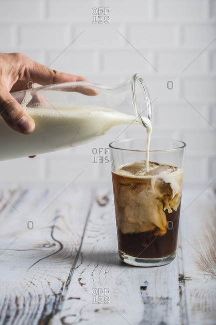Pouring milk in an iced coffee