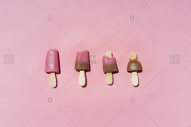 Bright popsicles placed on pink background