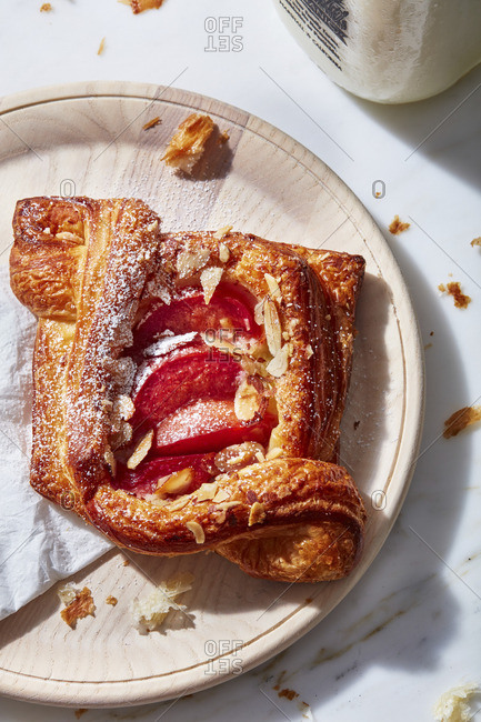 Danish pastry filled with fruit on a wooden plate