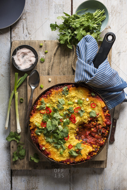 Vegan pie with tomatoes, red kidney beans, corn spiced with smoked paprika and cumin and topped with polenta, spring onions, chilli and coriander