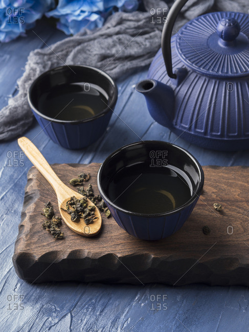 Green tea in blue cups with blue cast iron tea pot
