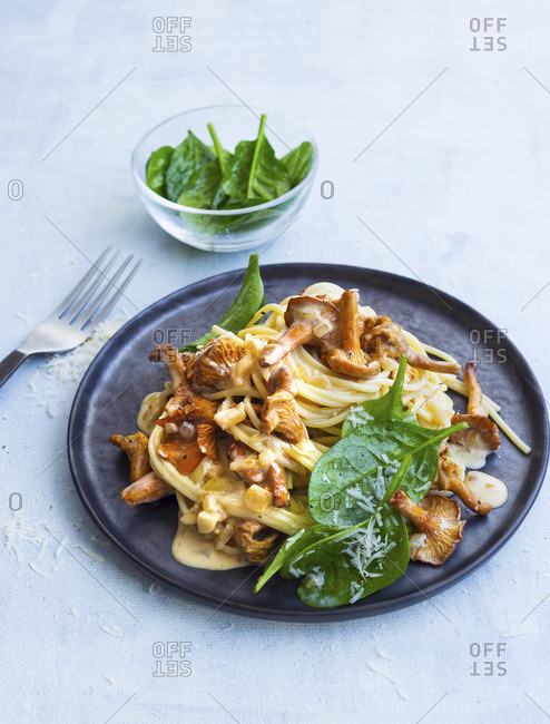 Spaghetti with chanterelle mushrooms and a creamy sauce served with a spinach salad
