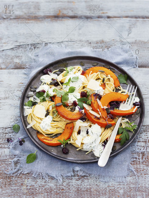 Spaghetti with baked pumpkin wedges and a yoghurt and herb sauce