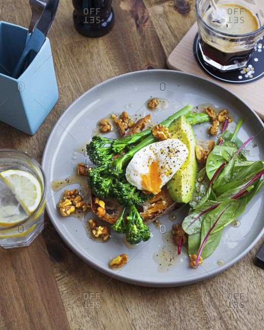 Toast with broccolini, poached egg, avocado and walnuts