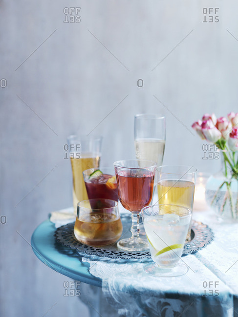 Various cocktails on a table with a flower vase
