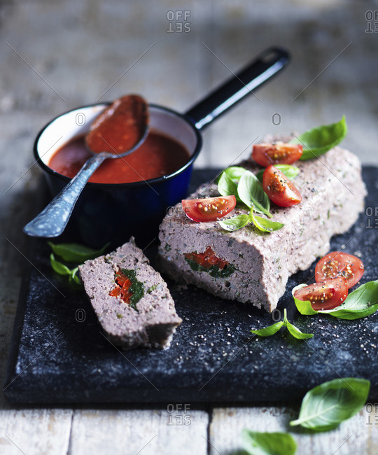 Meatloaf with a spinach and tomato filling served with tomato sauce