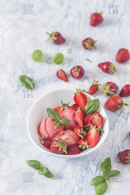 Strawberry ice cream with fresh strawberries and basil