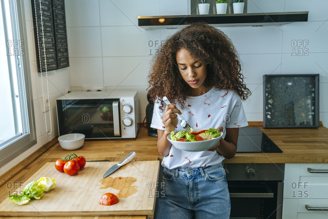 Woman with lettuce and tomato salad in the kitchen