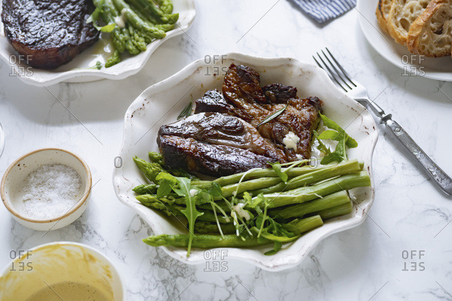 Cooked black angus prime beef steak with asparagus and cream mustard sauce. Top view dinner picture.