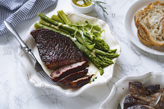 Cooked black angus prime beef steak with asparagus and cream mustard sauce. Top view dinner picture.