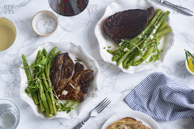 Cooked black angus prime beef steak with asparagus and cream mustard sauce. Top view dinner picture.