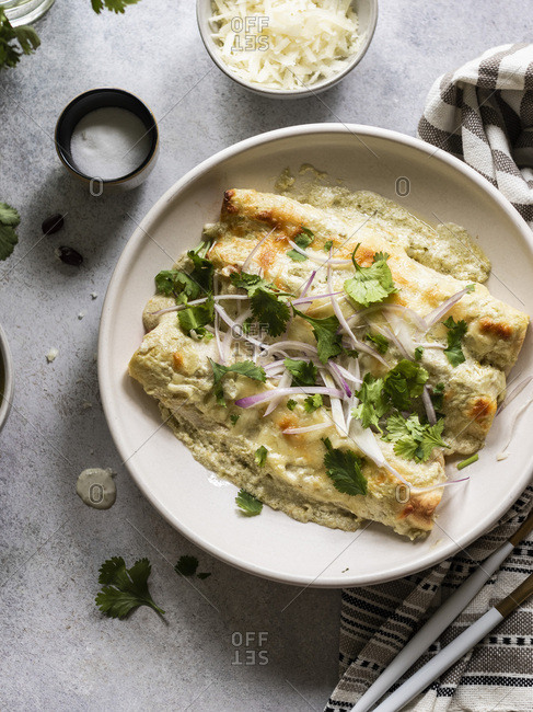 Cheesy enchiladas filled with chredded chicken and black beans, served with  creamy sauce