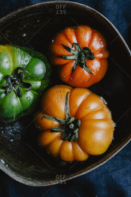 Three colorful tomatoes into the water