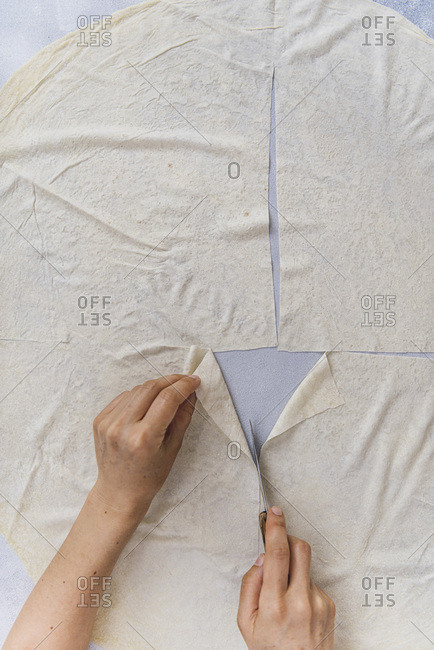 Woman cutting phyllo sheets to make Turkish sigara borek