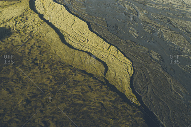 Sunset shadows reaching over dried out glacial rivers near Argil, a beautiful mountain area in Southern Iceland. The icecap in the background is Myrdalsjokull, Icelands 4th largest.
