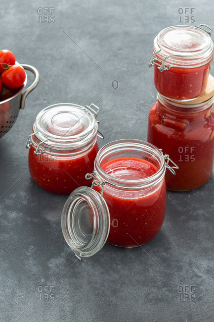 Tomato sauce in glass jars on a dark background