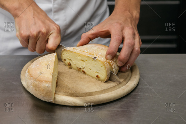 Slicing a wheel of cheese Stock Photo by ©photography33 82250564