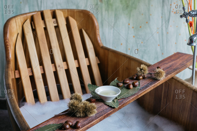 Overhead view of chestnuts and sauce on a wooden board over wooden bathtub