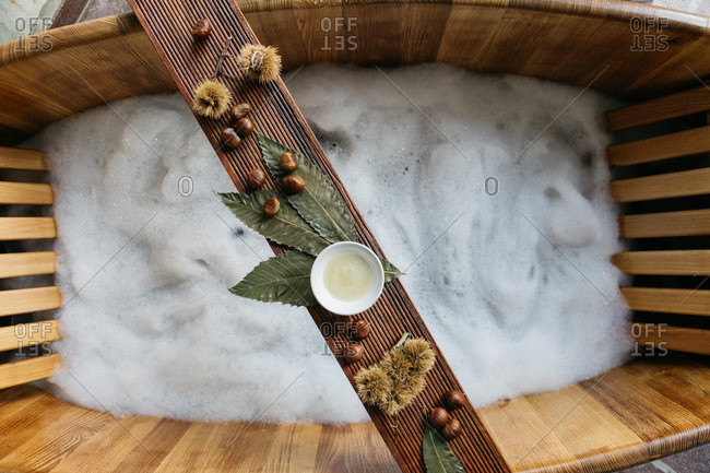 Chestnuts and sauce on a wooden board over wooden bathtub