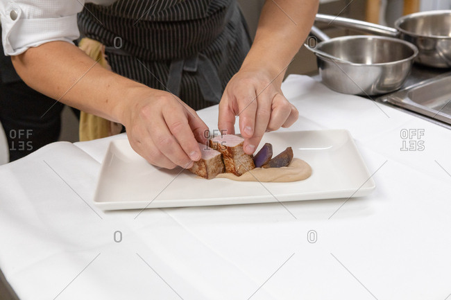 Chef preparing a gourmet meat dish in restaurant