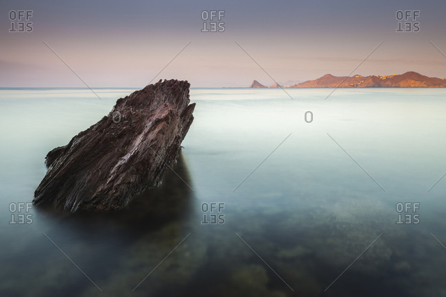 Scenic view of rock formation in sea against sky