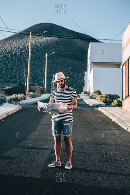 Male traveler standing with map