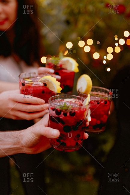 Group of cheerful friends clinking glasses at party