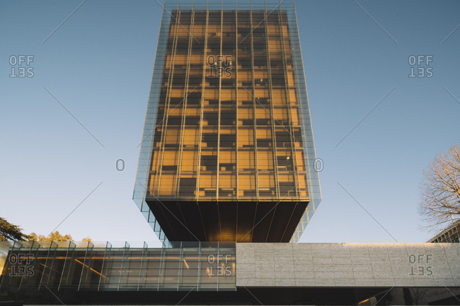 Madrid, Spain - January 2, 2019: Stylish glass skyscraper reflecting sun in bright day in downtown