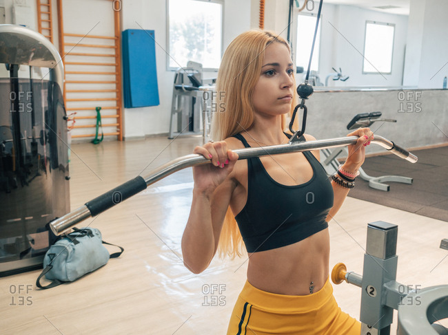 Premium Photo  Young woman working out on lat pulldown machine at gym