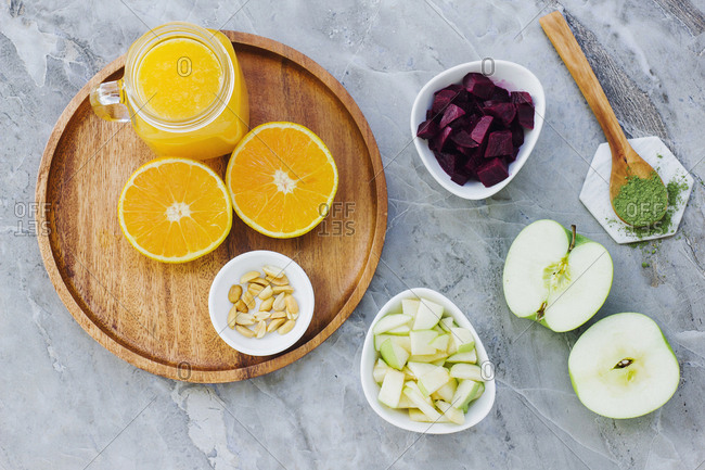 From above served oranges peanuts and orange juice on table with apples condiment and bowl of beets and apples