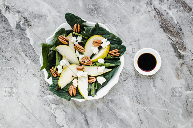 Served bowls with cut pears and pecan on table with pear walnuts