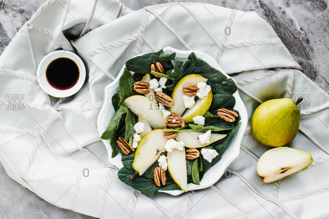 Served bowls with cut pears and pecan on table with pear walnuts