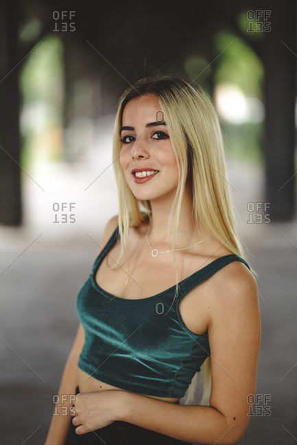 Beautiful blonde model smiling and looking at camera in berlin on blurred background looking at camera