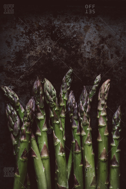 Close up of green asparagus on dark rustic background
