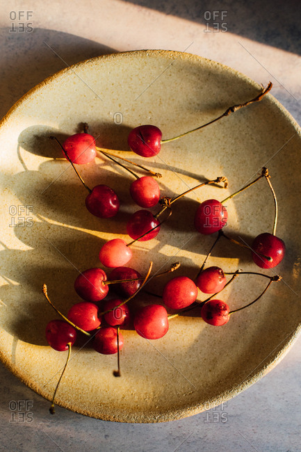 Cherries on a plate on light background