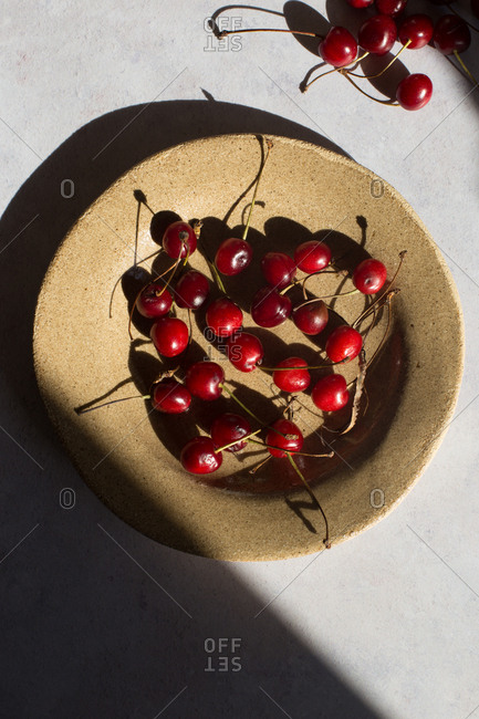 Cherries in a bowl on light background