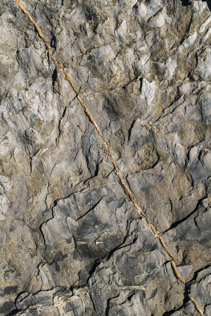 Texture on rocks with orange lines in rocky cliffs close to sea in Asturian Coast, Spain