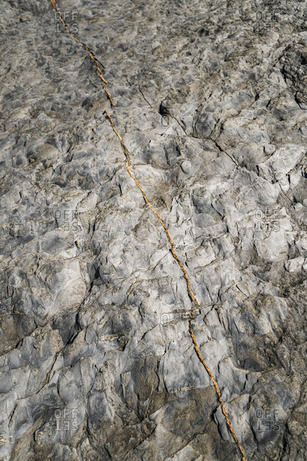 Texture on rocks with orange lines in rocky cliffs close to sea in Asturian Coast, Spain