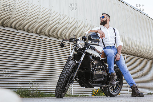 Young attractive man poses with motorcycle 1223963 Stock Photo at Vecteezy