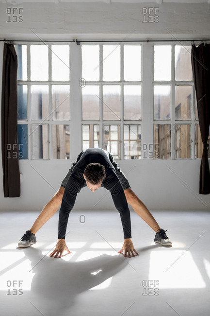 Athlete worming up in sunlit studio