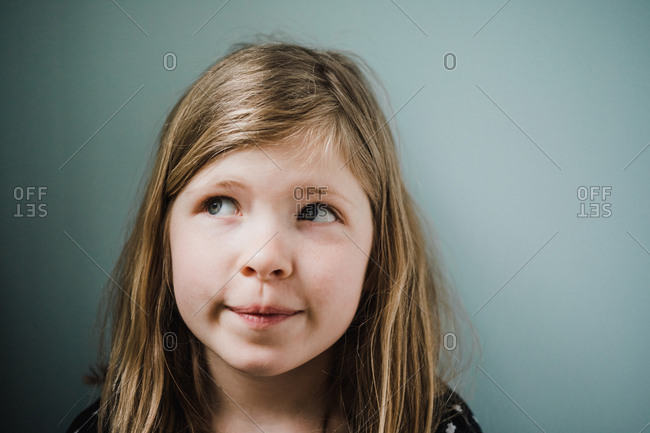 Portrait of an adorable blonde girl looking away