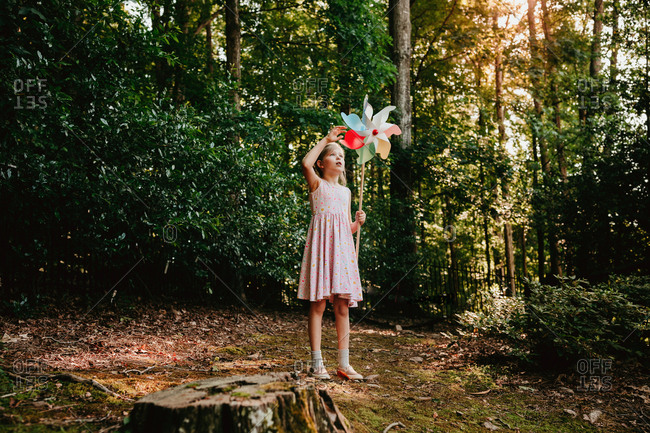 Girl in the forest spinning a pinwheel