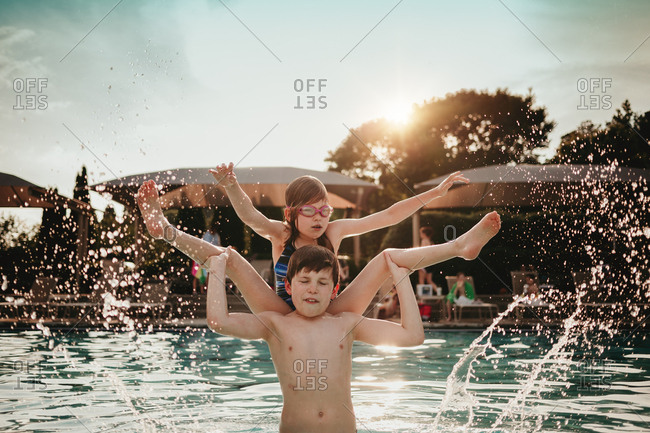 Brother flipping sister into a pool